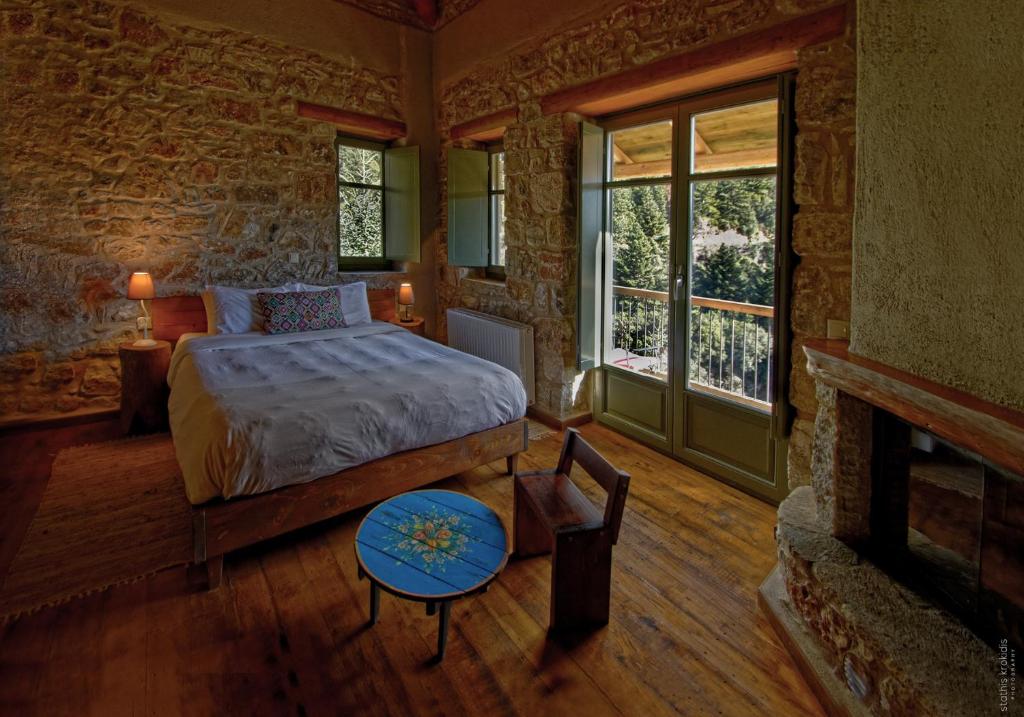 a bedroom with a bed in a room with a fireplace at Pritanio in Polídhroson