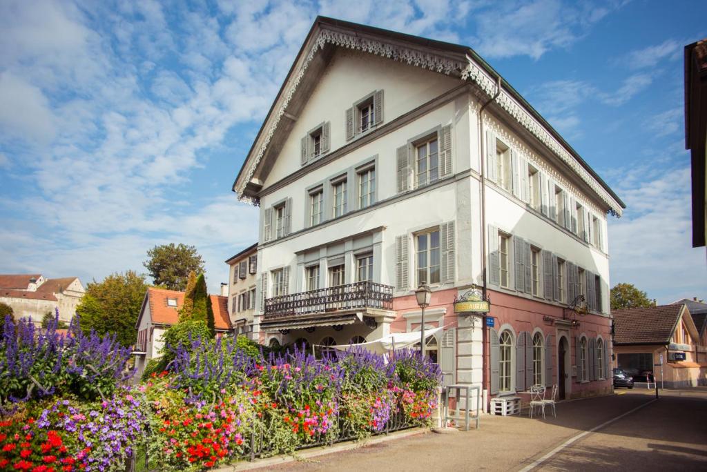 a white building with flowers in front of it at Auberge d'Ajoie in Porrentruy