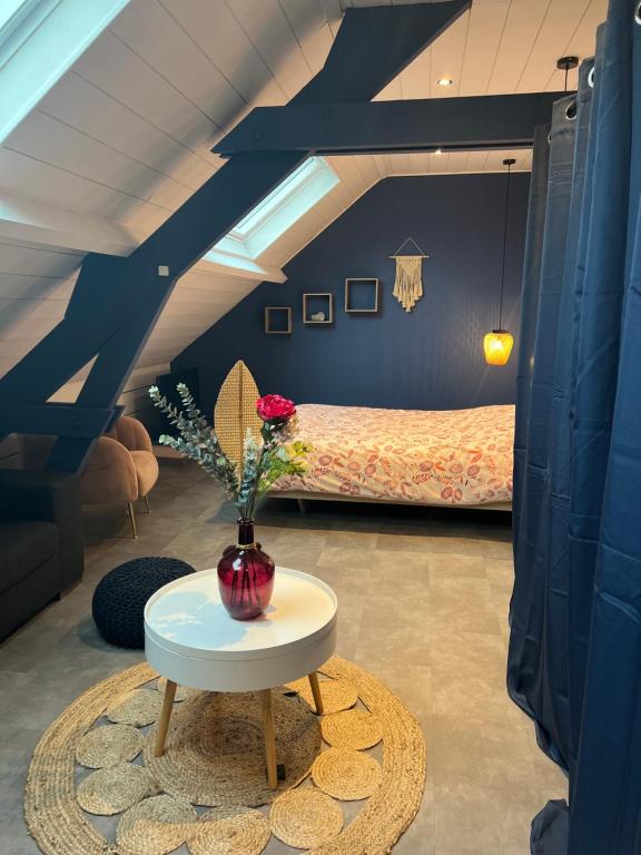 DuclairにあるChambre spacieuse Like&Love de Claraのベッド1台、花瓶1本(テーブル上)が備わる客室です。