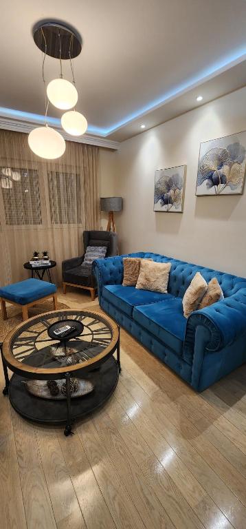 a living room with a blue couch and a table at City apartment in Podgorica