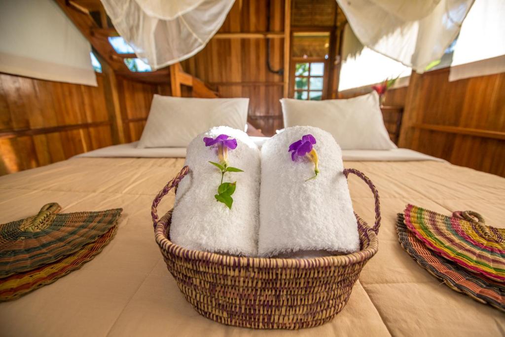 dos toallas en una cesta en una cama en Hacienda Herrera Tambopata, en Puerto Maldonado