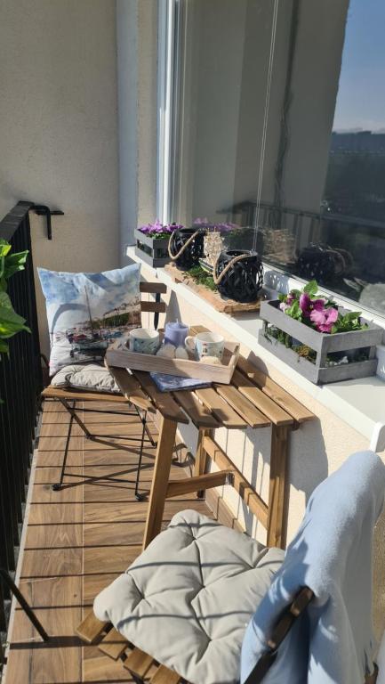 Zimmer mit einem Tisch und Stühlen auf einem Balkon in der Unterkunft apartament na fali in Danzig