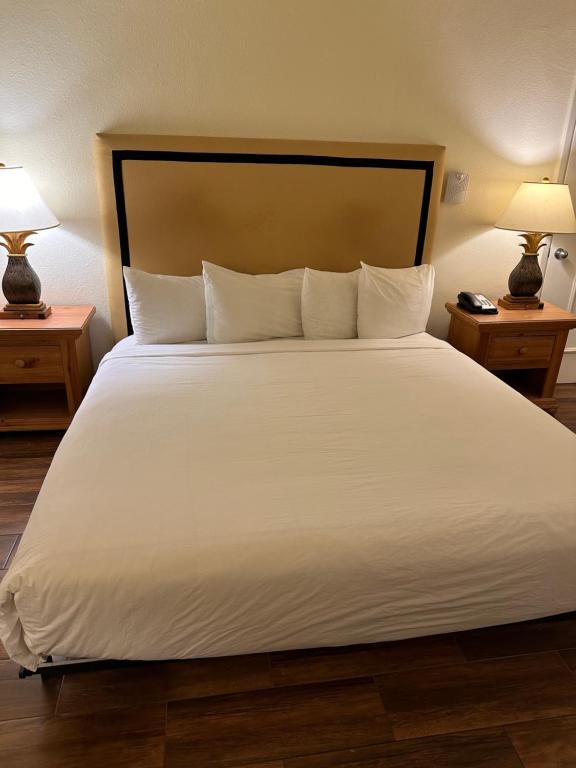 a large bed with white sheets and pillows at Ramada by Wyndham Las Cruces Hotel & Conference Center in Las Cruces