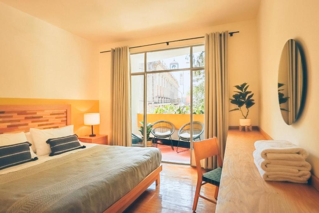 a bedroom with a bed and a large window at AirTabacalera in Mexico City