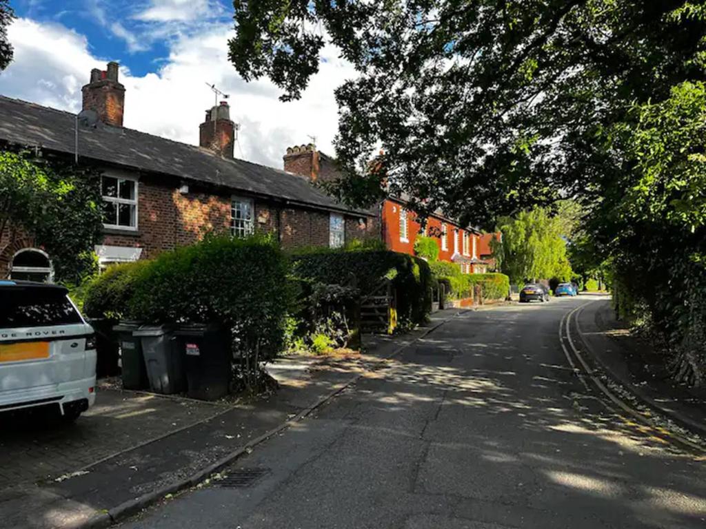 an empty street in a residential neighborhood with houses at Beautiful Period Victorian Home Quirky & Charming in Handforth