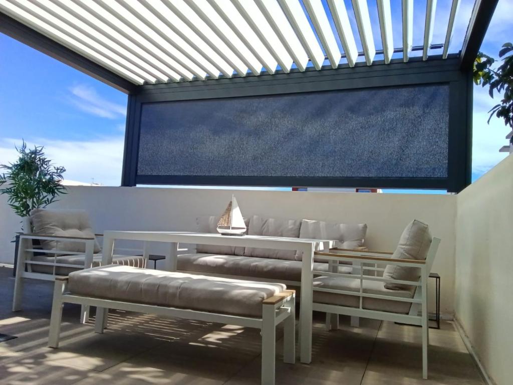 a patio with benches and a large window at 36 2 L'air marin maison duplex grande terrasse in Narbonne