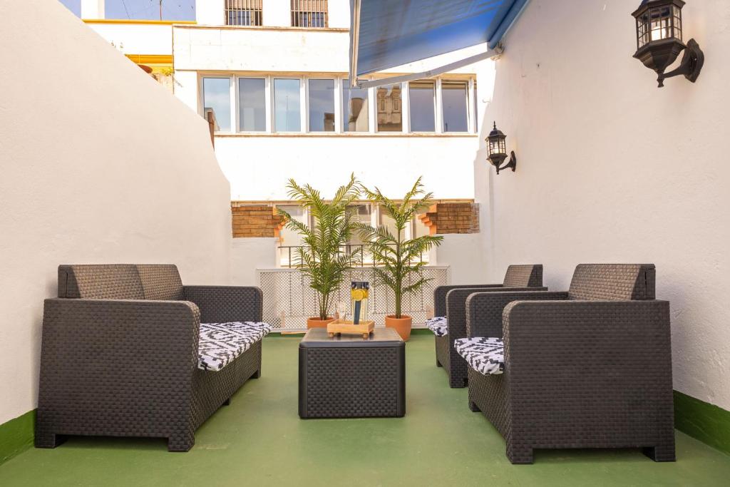 una fila de sillas y mesas de mimbre en un patio en New! La Casa del cerrajero, en Sevilla