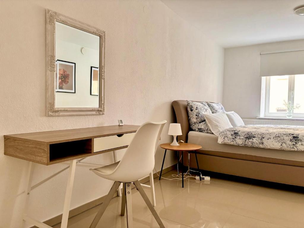 班貝格的住宿－Denkmal-Wohnung in Bamberg，一间卧室配有书桌和一张带镜子的床