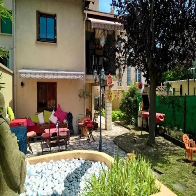 une arrière-cour avec un foyer extérieur et une maison dans l'établissement Maison Bezons: Confort & Jardin, à Bezons