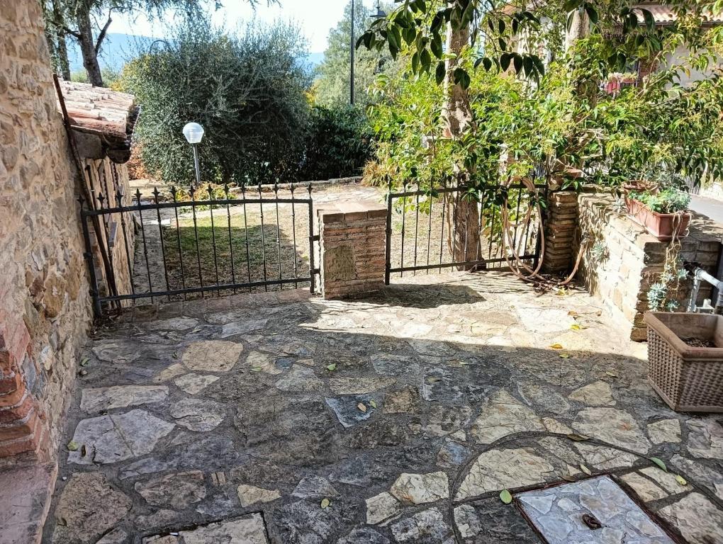 un cancello per un giardino con patio in pietra di Trame di luce a Pietrafitta