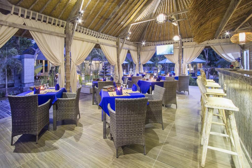 a dining room with blue tables and chairs at The Palm Grove Villas - CHSE Certified in Nusa Lembongan