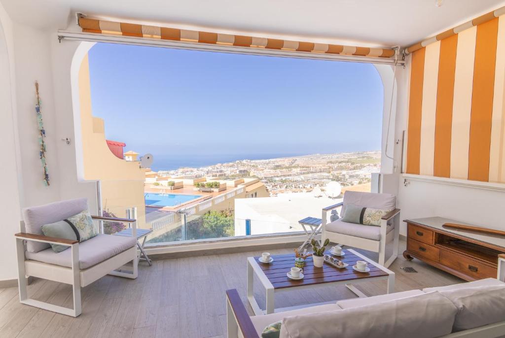 un soggiorno con divano, sedie e una grande finestra di Mirador Balcon del Atlantico y piscina privada ad Adeje