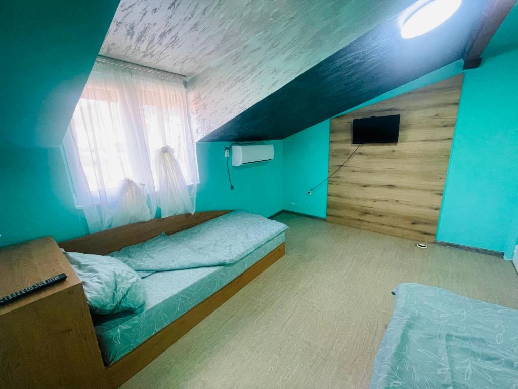 Habitación pequeña con cama y ventana en Вила Маца, en Sapareva Banya