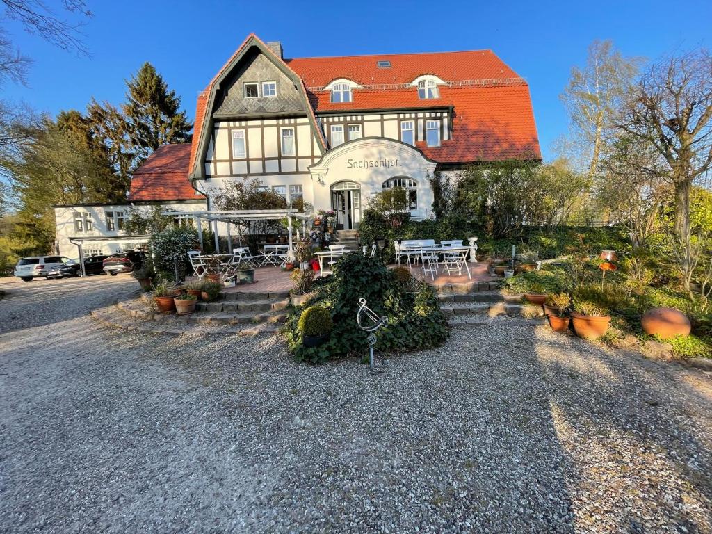 a large house with an orange roof and some plants at romantische Ferienwohnung Sachsenhof 2 in Klingberg
