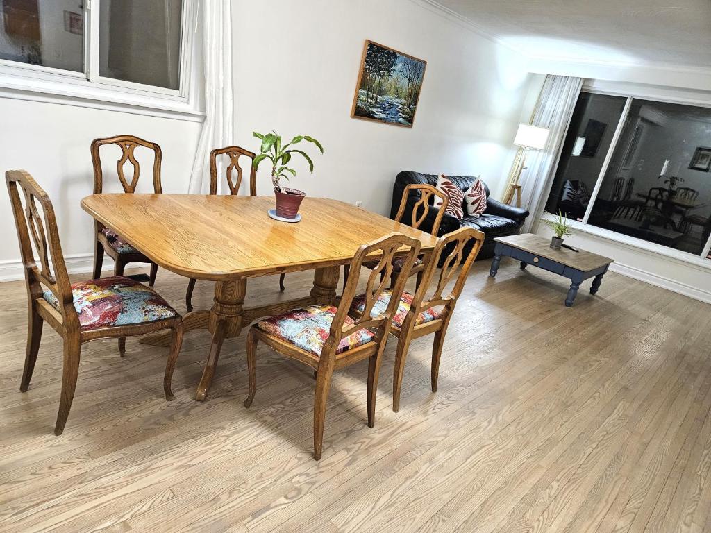 a dining room with a wooden table and chairs at Charming 3 bedrooms detached house near the airport in Mississauga