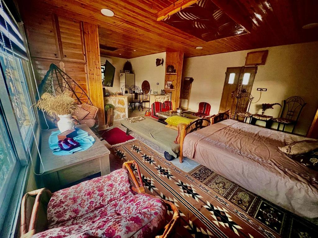 - une chambre avec un lit et un canapé dans l'établissement Oak Farm مزرعة الملّول, à Ajloun