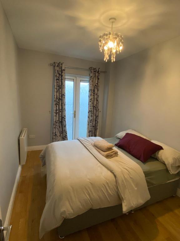 1 dormitorio con cama y lámpara de araña en Cosy Dublin apartment en Dublín