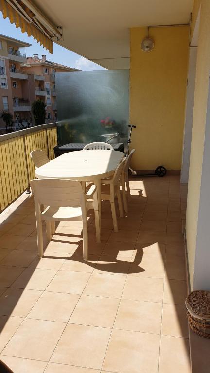 une table blanche et des chaises sur un balcon dans l'établissement appartement frejus plage, à Fréjus
