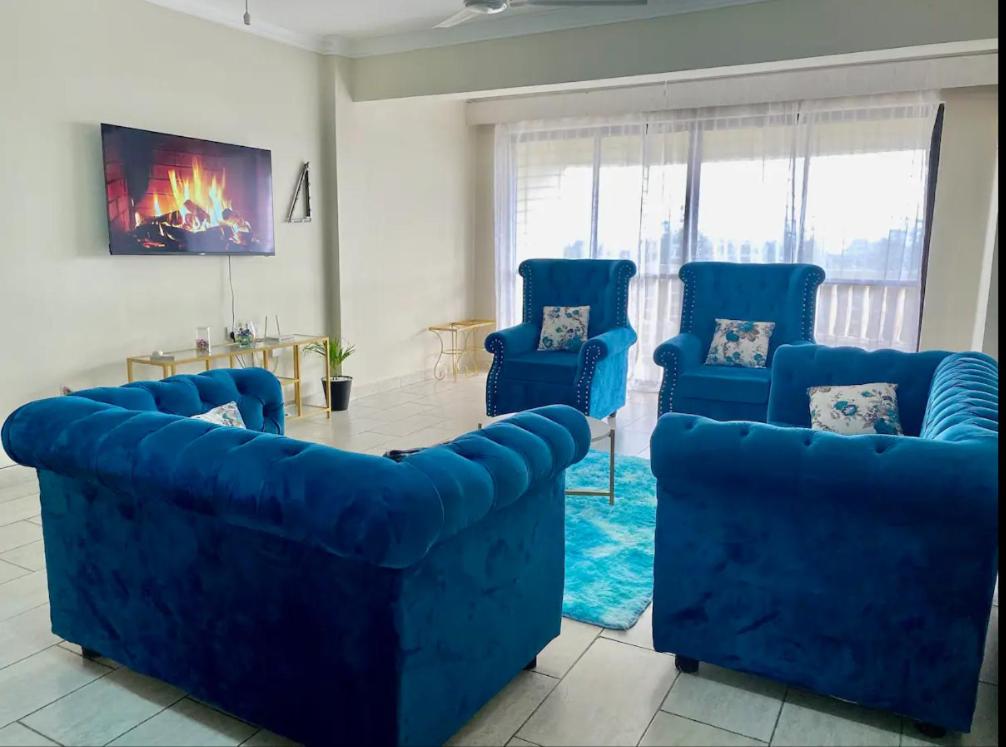 a living room with blue couches and a table at deep east in Ruiru