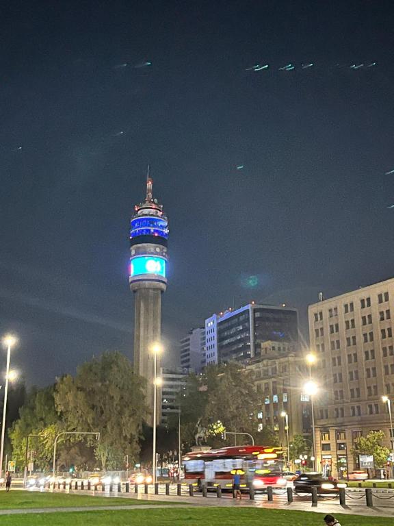 una torre alta con luces azules en ella por la noche en Departamento Santiago Centro Full Equipado, en Santiago