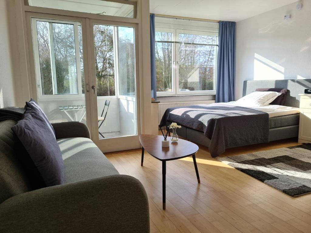 a bedroom with a bed and a couch and a table at Bayer Apartments Copenhagen in Rødovre