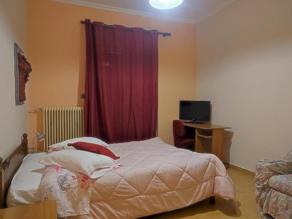 a bedroom with a bed with a red curtain at Mema's Tranquil Studio in Patra - Free Parking in Patra