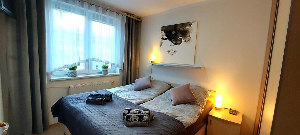 a bedroom with a bed with two bags on it at Apartament Orange in Ostróda