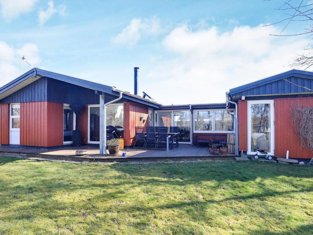 een rood huis met een patio en een tuin bij Holiday home Vinderup XXII in Vinderup