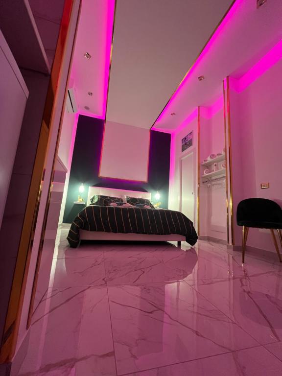 a bedroom with purple lighting and a bed on the floor at Regina House in Naples