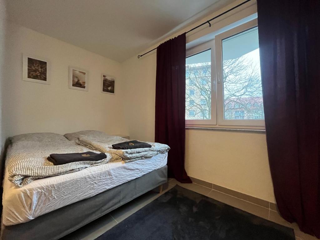 a bedroom with a bed and a window at Simplex Apartments Am Europaplatz in Karlsruhe