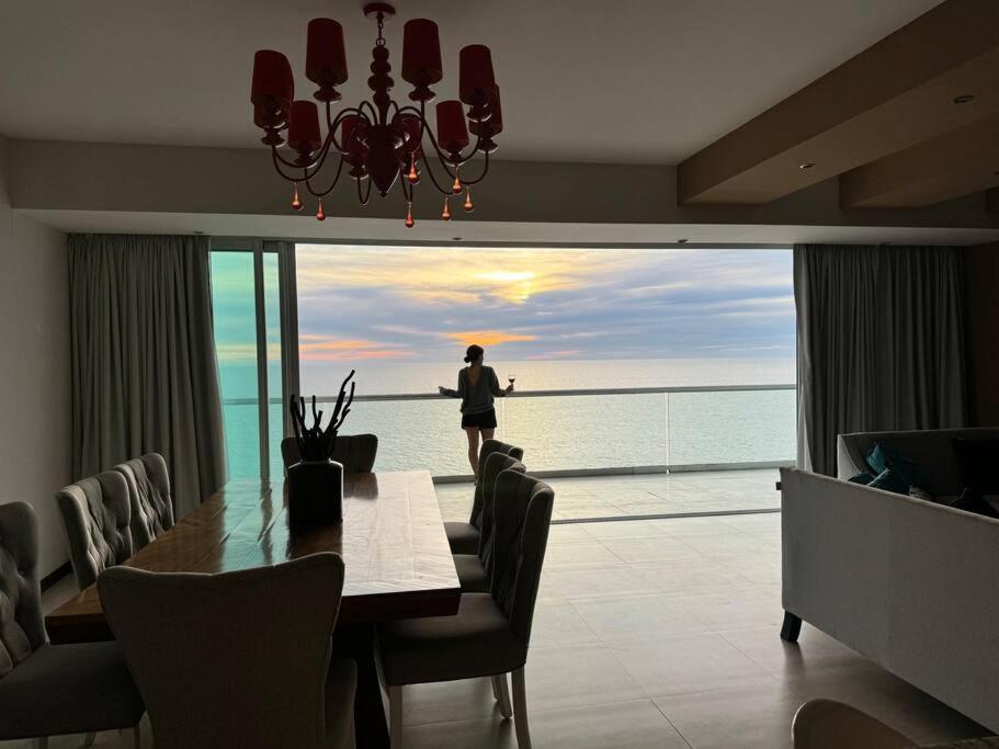 a dining room with a table and a view of the ocean at Departamento de Lujo Vista al mar Piso 15 in Mazatlán