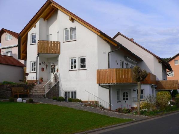 a large white house with wooden balconies on it at gepflegte Ferienwohnung in ruhiger Lage in Bad Kissingen