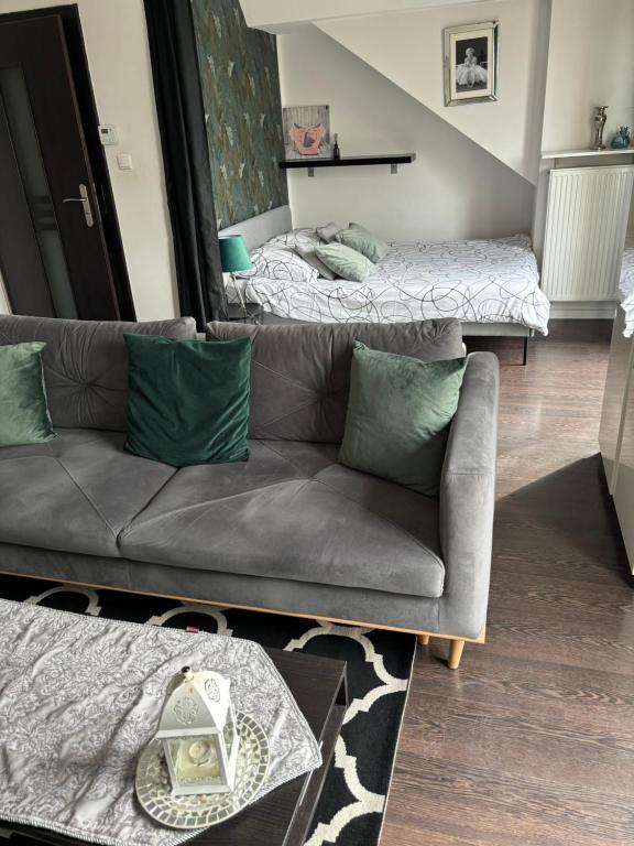 uma sala de estar com um sofá e 2 camas em Apartament Trocera em Zabrze