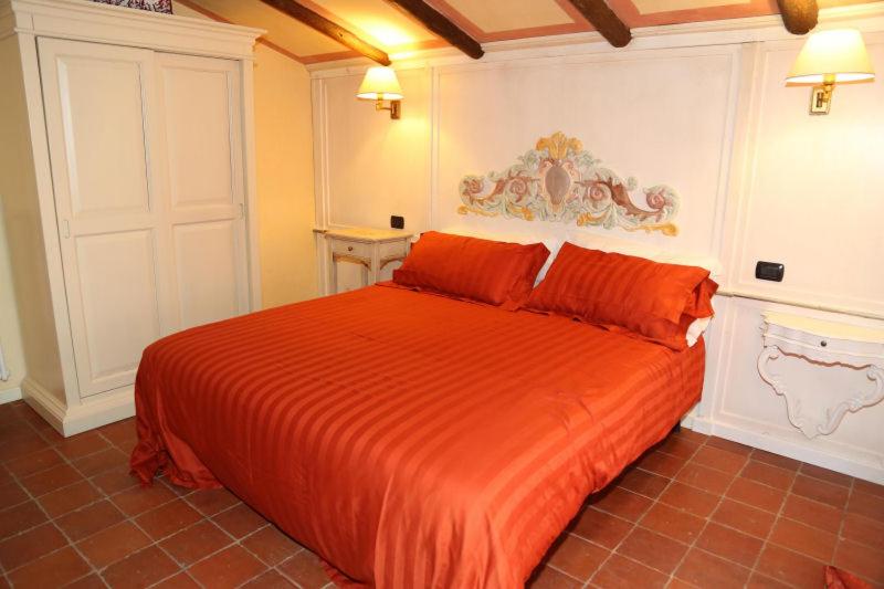 ボルゴ・ヴァル・ディ・ターロにあるBorgo Tiedoliのベッドルーム1室(オレンジ色の毛布付きのベッド1台付)
