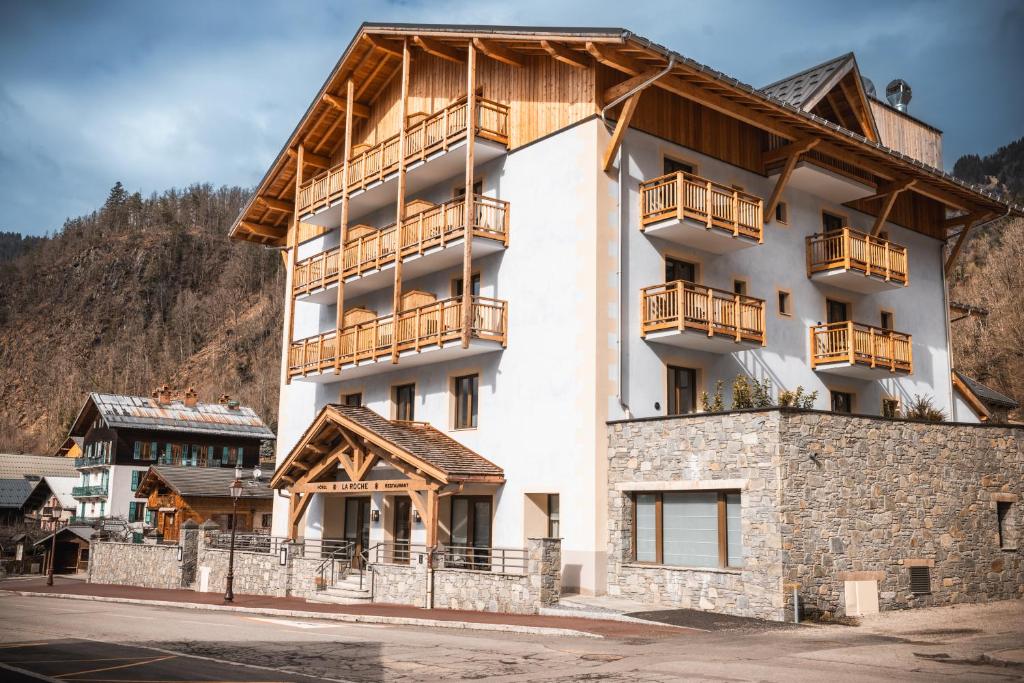 a large white building with wooden balconies on it at Hôtel de la Roche in Beaufort