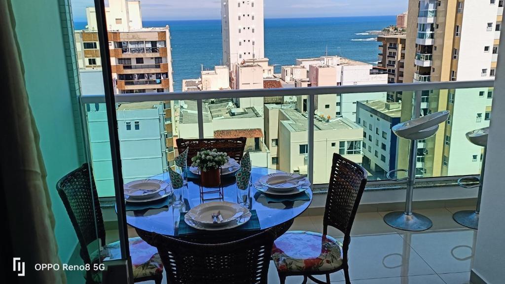 a table on a balcony with a view of the ocean at Magnifico apto com vista para o mar!!!! in Guarapari