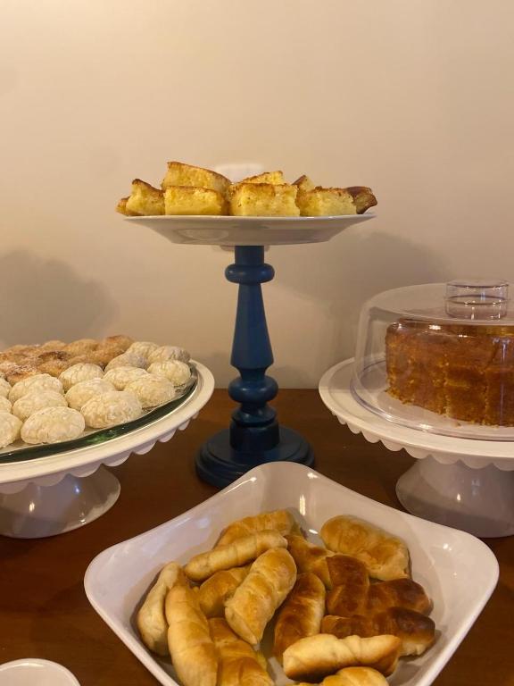 a table with three plates of pastries and a tray of food at Pousada Mãe Natureza in Pirenópolis