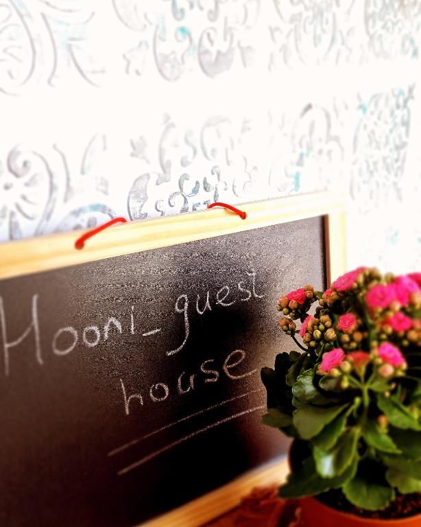 a chalk board with a sign next to a plant at Hooni_guesthouse in Odzun