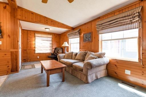 sala de estar con sofá y mesa en 3br Riviera Cabin Sleeps 6, Fully Furnished!, en Neillsville