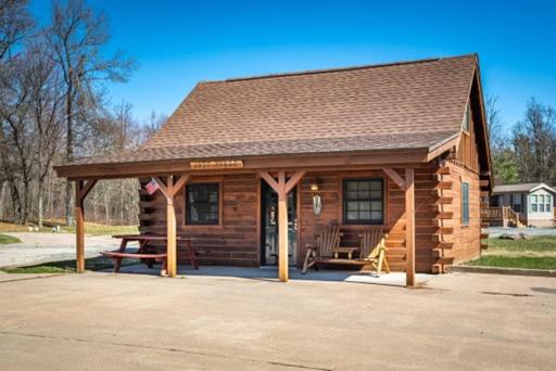 a log cabin with a picnic table and a bench at Sleeps 7 Rustic Loft At Riviera Resort! in Neillsville