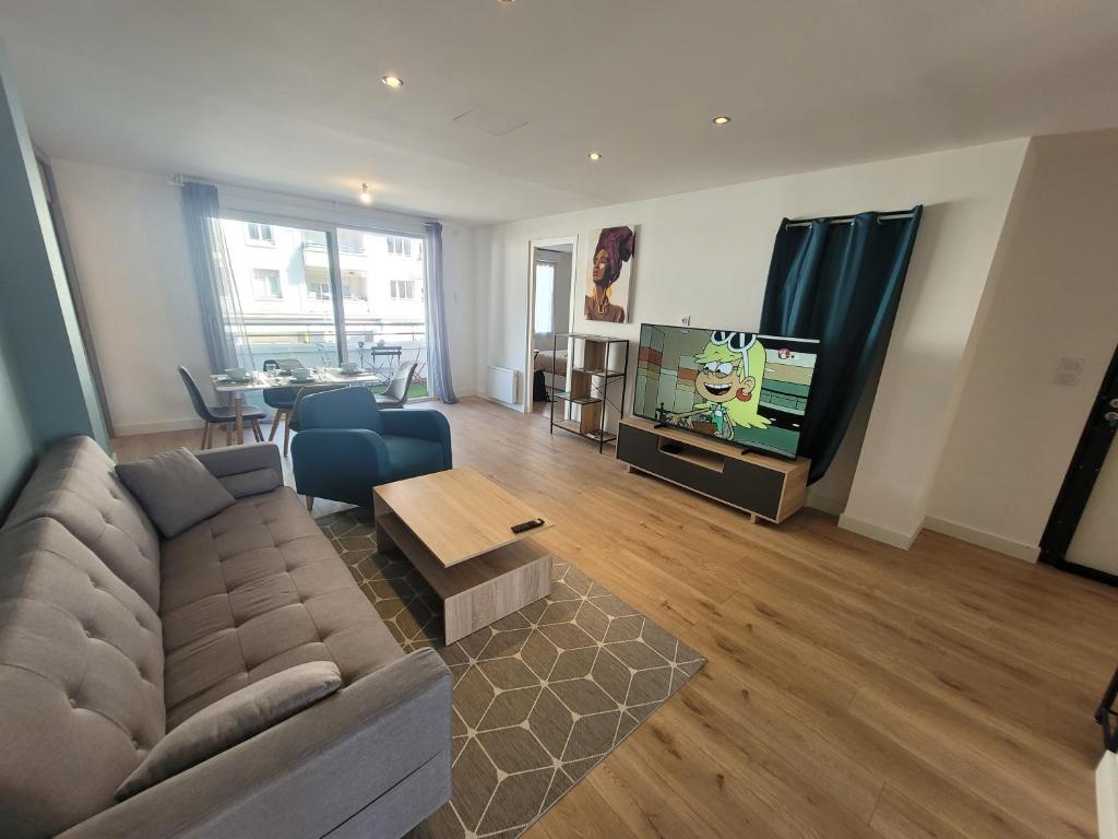 un salon avec un canapé et une télévision dans l'établissement Appartement hyper-centre, à Saint-Nazaire