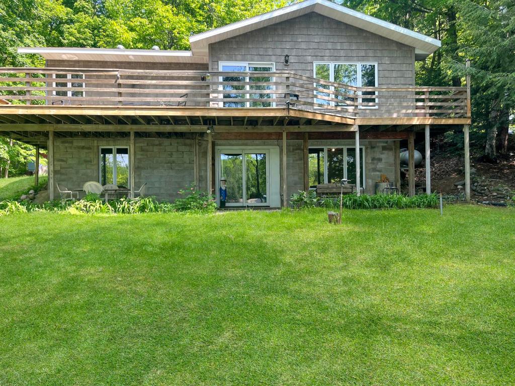 una casa con terraza en la parte superior de un patio en 2br Lakeside Haven Relax On Long Lake, en Gleason