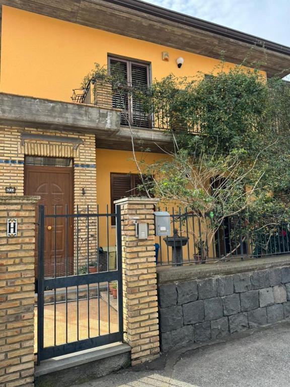 a yellow house with a gate and a fence at Lilly & Gisa casa vacanze in Pedara