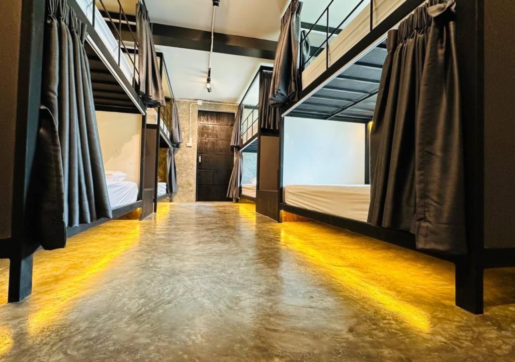 a hallway with three bunk beds in a room at Adora Hostel in Chiang Mai
