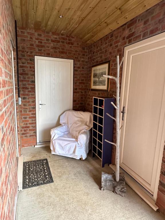 um quarto com uma cama numa parede de tijolos em The Stable Room at The Grange em Lincolnshire