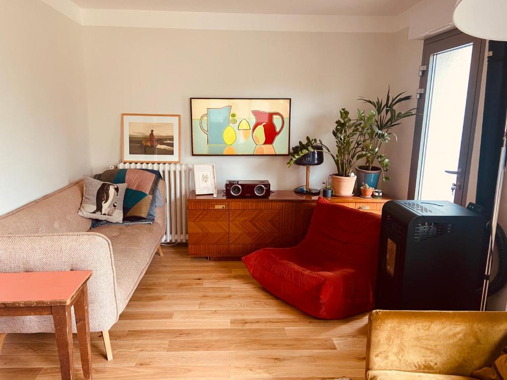 - un salon avec un canapé et un pouf rouge dans l'établissement Cosy house in Versailles - Paris 2024, à Versailles