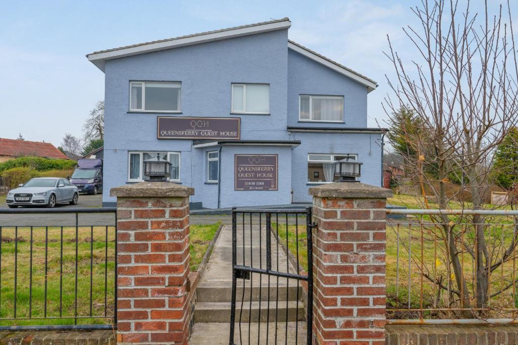 a blue house with a gate in front of it at Queensferry Guest house in Rosyth