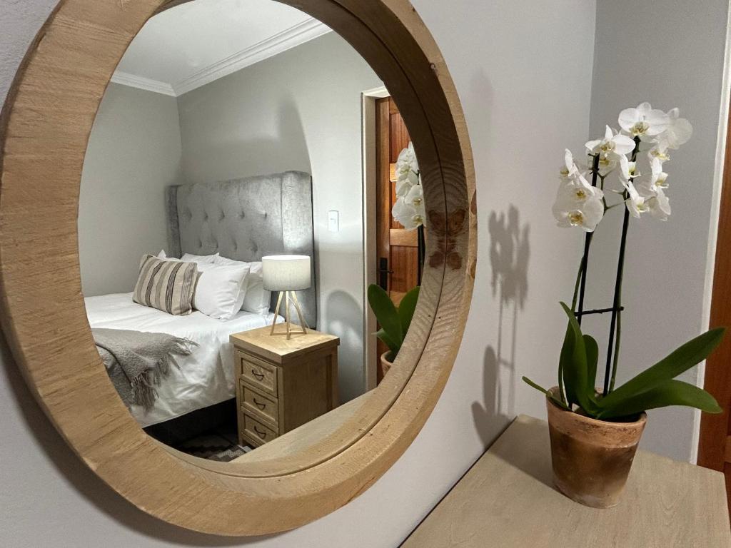 a mirror in a bedroom with a bed at Hansen@15 Self Catering Studio in Piet Retief