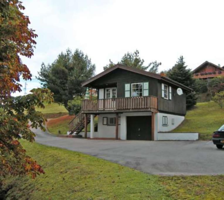 una casa en una colina con un coche aparcado en la entrada en Le P'tit Caribou, près des pistes, en Gérardmer