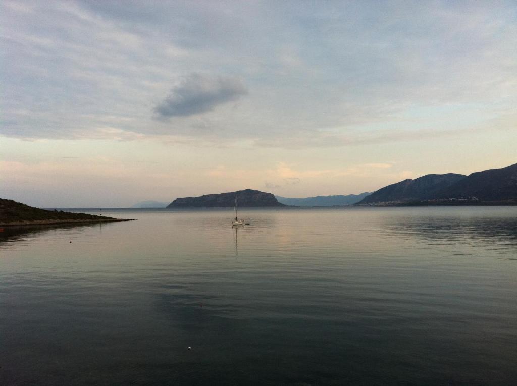 a sailboat on a lake with mountains in the background at Annema Hotel and Restaurant in Monemvasia